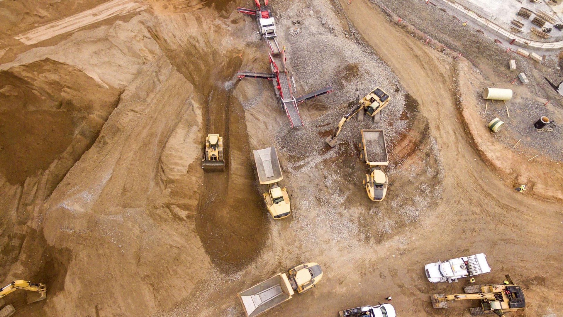 Aerial view of haul trucks and loaders on an earthworks site